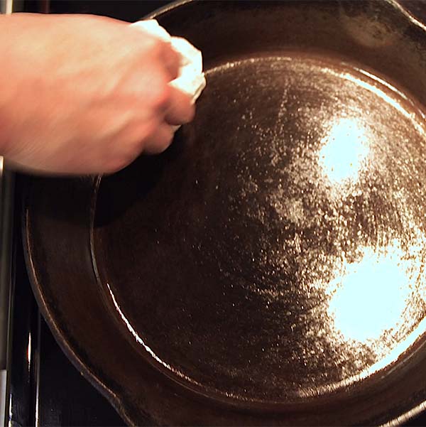 Finally, with another paper towel, wipe away excess oil from the surface to clean, care for cast iron Dutch oven or skillet.