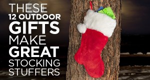 A Christmas stocking hung outdoors on a tree trunk.
